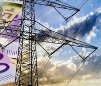 Strommast und Geldscheine, die Bundesnetzagentur plant eine Reform der Netzentgelte.