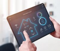 Hände halten ein Tablett mit Smart-Home-Steuerung, dynamische Stromtarife sind laut Verivox nicht günstiger als Festpreistarife.