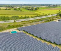 Luftbild von einem Solarkraftwerk an einer Autobahn, der LEE NDS/HB fordert bessere Rahmenbedingungen für den Ausbau der Freiflächen-Photovoltaik in Niedersachsen.