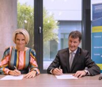 Zu sehen sind Nicole Dreyer-Langlet von Airbus und Markus Fischer von dem DLR, die die Kooperationsvereinbarung zum Klimaschutz im Luftverkehr unterzeichnen.