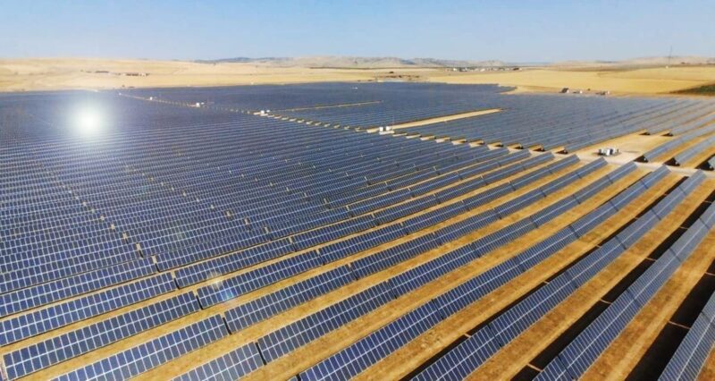 Blick über eine 50 MW große PV-Anlage in trockener heißer Landschaft.