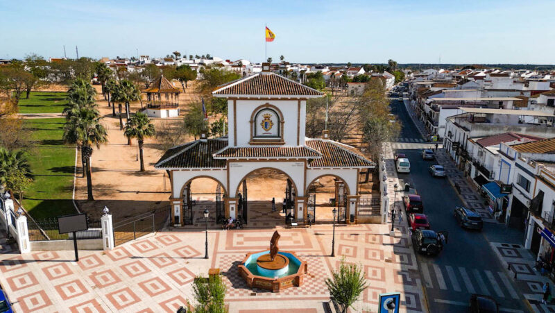 Stadtansichten einer spanischen Stadt mit einem weißen Stadttor auf einem Festplatz.