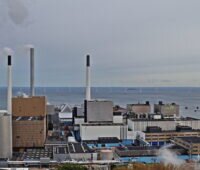Müllkraftwerk von Kopenhagen-Amager mit rauchenden Abgasschloten am Meer.