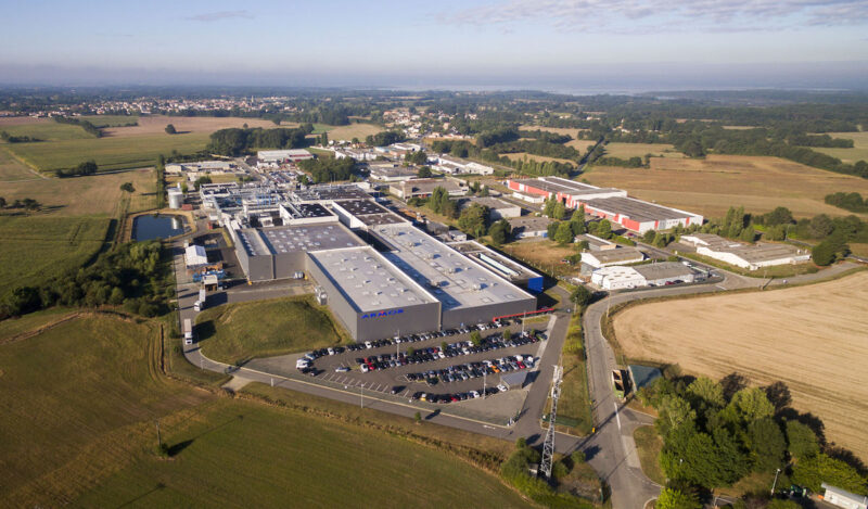 Luftaufnahme eines Fabrikgebäudes - Hauptsitz von Asca für die Herstellung Organischer Photovoltaik