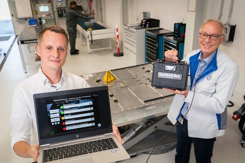Zu sehen sind die Audi-Mitarbeiter Robin Krause und Joachim Wöhle, die mit Battman ReLife E-Auto-Batterien auf ihre Tauglichkeit zum Second Lift testen.