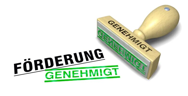 Im Bild ein Stempel mit der Aufschrift Förderung genehmigt, als Symbol für die Wiederaufnahme der Bundesförderung für effiziente Wärmenetze (BEW).