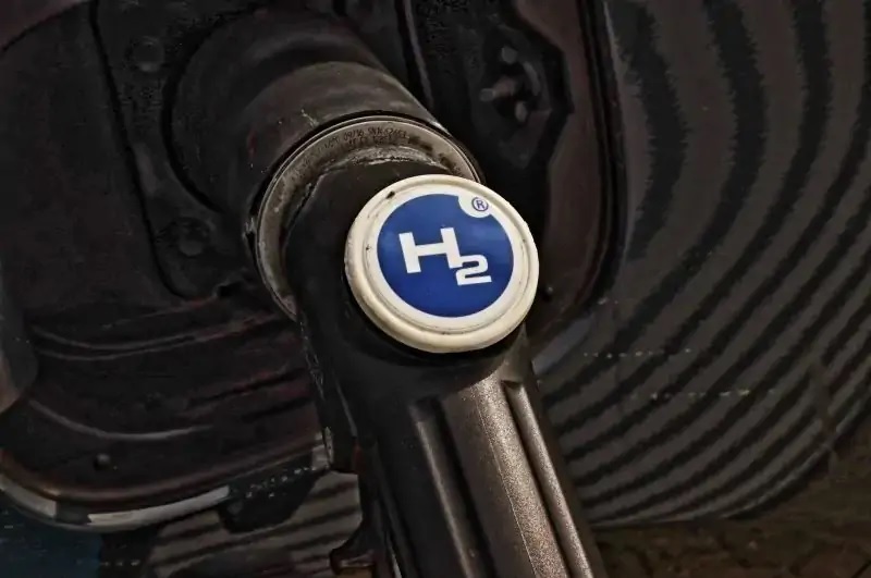 Zu sehen ist ein Auto, das mit Wasserstoff betankt wird als symbolische Darstellung für die Reduktion der EEG-Umlage bei der Wasserstoff-Herstellung.