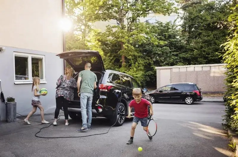 Im Bild eine Familie mit E-Auto, der BDEW-Elektromobilitätsmonitor sieht Fortschritte bei der E-Mobilität.