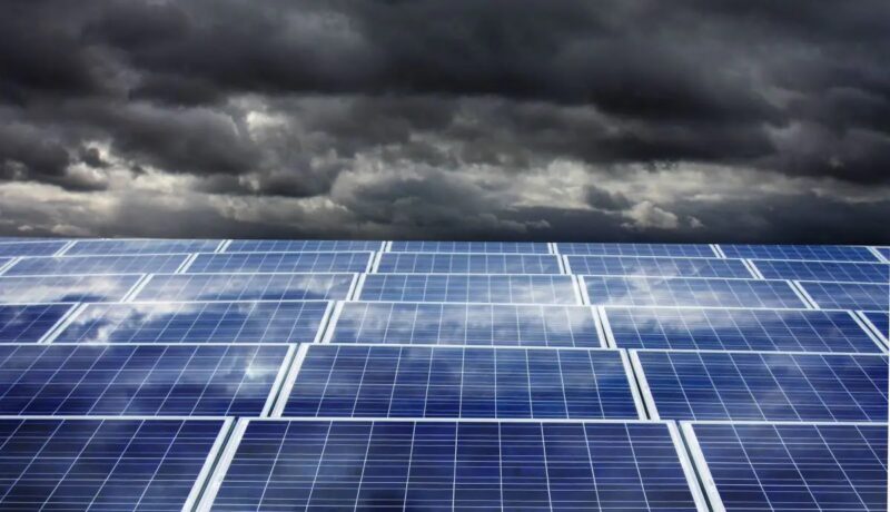 Im Bild dunkle Wolken über eine PV-Anlage als Symbol für die bisher mangelnde Resilienz in der Energiewirtschaft.