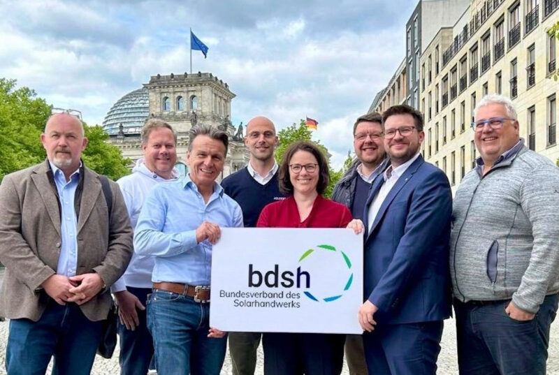 Sieben Menschen halten ein Schild mit der Aufschrift "BDSH - Bundesverband des Solarthandwerks"