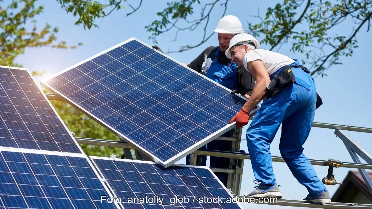 Im Bild zwei Monteure, die ein Photovoltaik-Modul installieren. Das Solarspitzen-Gesetz lässt Praxisfragen ungeklärt.