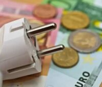 Ein Stecker und Geldscheine als Symbol für den EEG-Finanzierungsmechanismus.