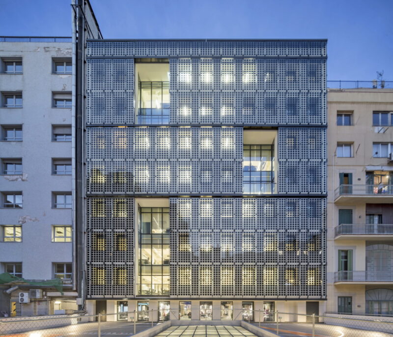 Eine Gewerbeimmobilien mit einer Fassade von durchlässigen Photovoltaikmodulen.