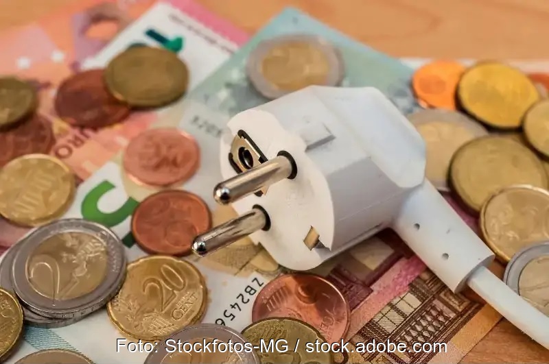 Zu sehen ist ein Stromstecker und Geldmünzen als Symbol für den Gesetzentwurf zur Abschaffung der EEG-Umlage.