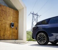 Links ist ein Garagentor zu sehen, rechts angeschnitten ein E-Auto.