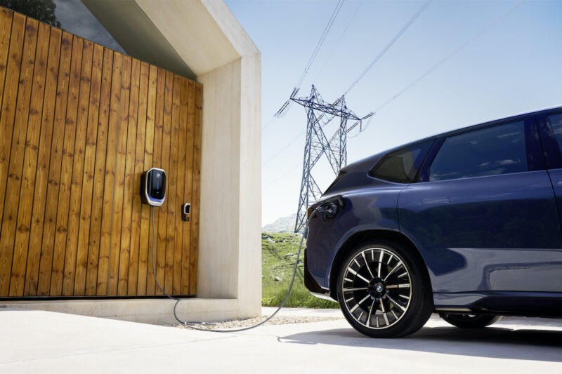 Links ist ein Garagentor zu sehen, rechts angeschnitten ein E-Auto.