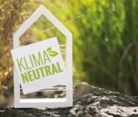 Im Bild ein Umriss eines Hauses mit der Aufschrift „Klimaneutral“ als Symbol für die Novelle des Gebäudeenergiegesetzes (GEG).