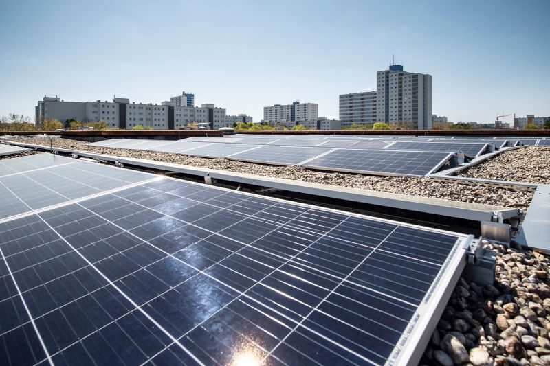 Eine PV-Anlage auf einem Flachdach, in der die Sonne reflektiert.