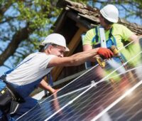 Zu sehen sind zwei Handwerker, die eine Photovoltaik-Anlage installieren. Mit dem Solar-Beschleunigungspaket, das Klimaminister Robert Habck plant, könnte es demnächst noch viel mehr davon geben.