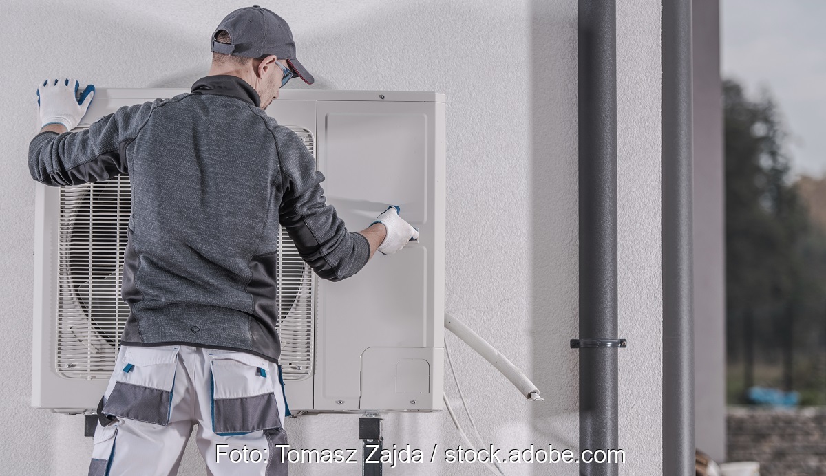 Im Bild ein Monteur bei der Wärmepumpeninstallation als Symbol für den Wärmepumpenhochlauf.