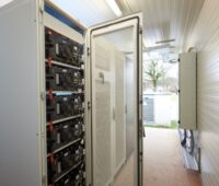 Hoher Batterie-Schrank mit einer geöffneten Tür.
