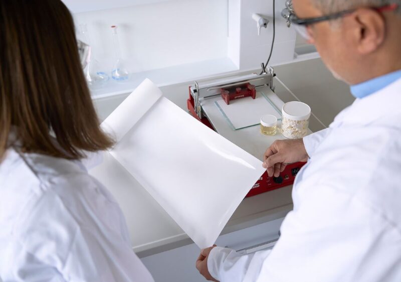 Forschende im Labor mit weißem Materialbogen zur Produktion von Separatoren für Batterien.