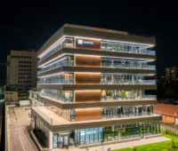 Das hellerleuchtete SUNOTEC-Gebäude bei Nacht: Bis zu 230 MWh – SUNOTEC Germany baut Batteriespeicher für die SEAC Group.