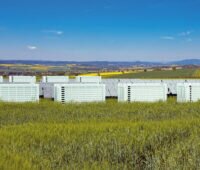 Photovoltaikpark mit mehreren weißen Batteriespeichern - vermutlich Fotomontage