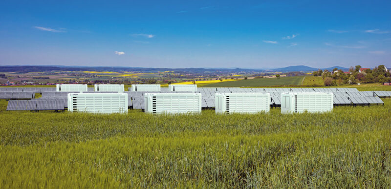 Photovoltaikpark mit mehreren weißen Batteriespeichern - vermutlich Fotomontage