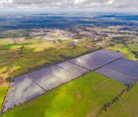 Luftaufnahme eines PV-Parks im landwirtschaftlich geprägten Flachland.