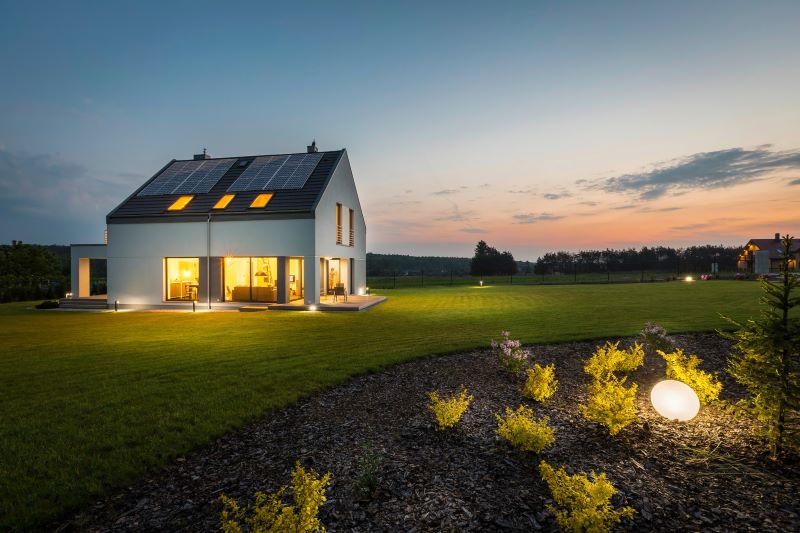 Ein beleuchtetes Haus alleinstehend bei spätem Sonnenuntergang