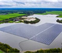 Eine schwimmende PV-Anlage umgeben von Grün.