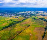 Luftaufnahme einer ungenützten Landfläche in grün-btaunen Farbtönen.