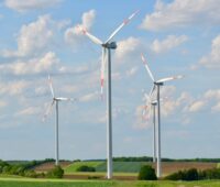Ü20-Windenergie-Anlagen vor blauem Himmel mit Schäfchenwolken