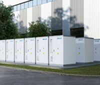 Batteriespeicher vor einer Halle, Baywa re Solar Trade vertreibt WHES-Batteriespeicher.