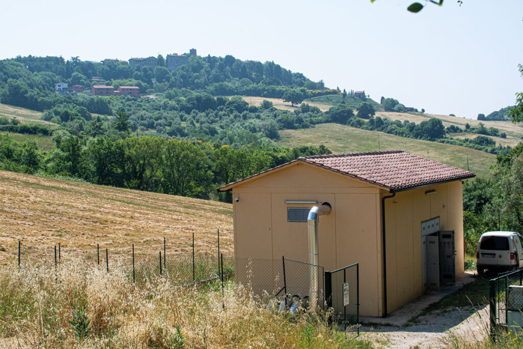 Ein Gebäude mit einer Übergabestation für Fernwärme aus Geothermie in freier Lanschaft der Toskana.