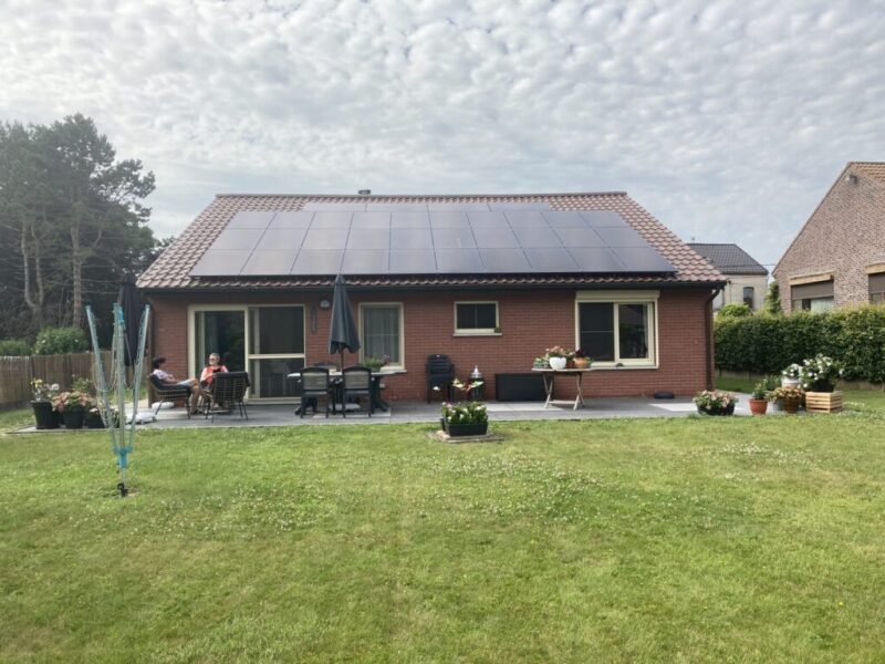 Einfamilienhaus mit Schrängdach und schwarzen Modulen.
