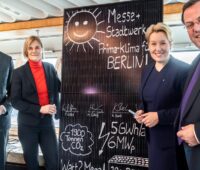 Menschen mit beschriftetem Solarmodul