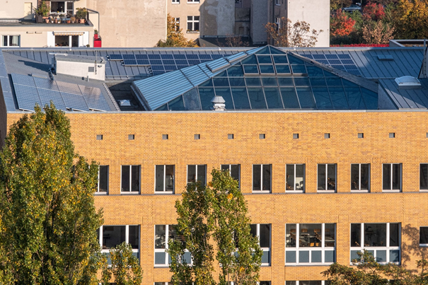 Auf dem verglasten Dach einer Fachhochschule sind Solarmodule installiert