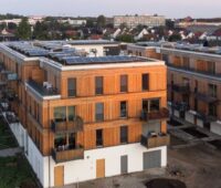 Zwei Berliner Neubauten in Holzbauweise mit PV auf den Dächern.
