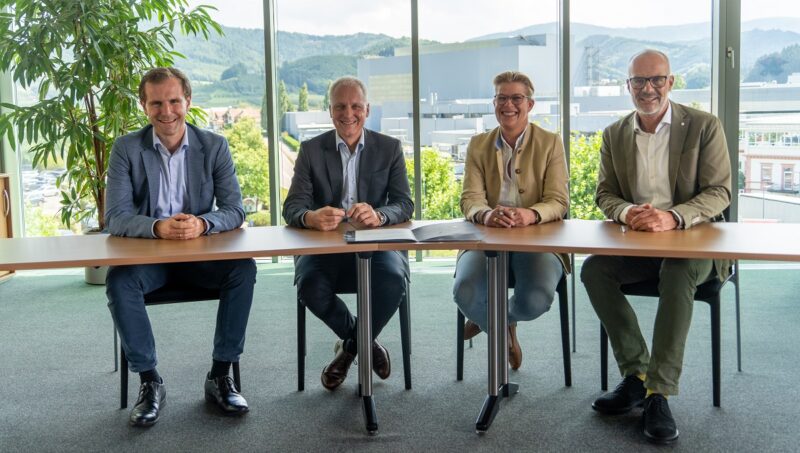 Firmenvertreterinnen von Koehler Renewable Energy und Iqony Solutions unterzeichnen Vertrag für Projekte, um Kohle durch Bioenergie zu ersetzen.