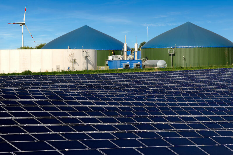 Biogas-Anlagen, PV-Anlage und im Hintergrund ein Windrad.