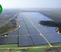 Luftaufnahme eines Solarparks mit im Bild eingebauter Brasilienflagge.