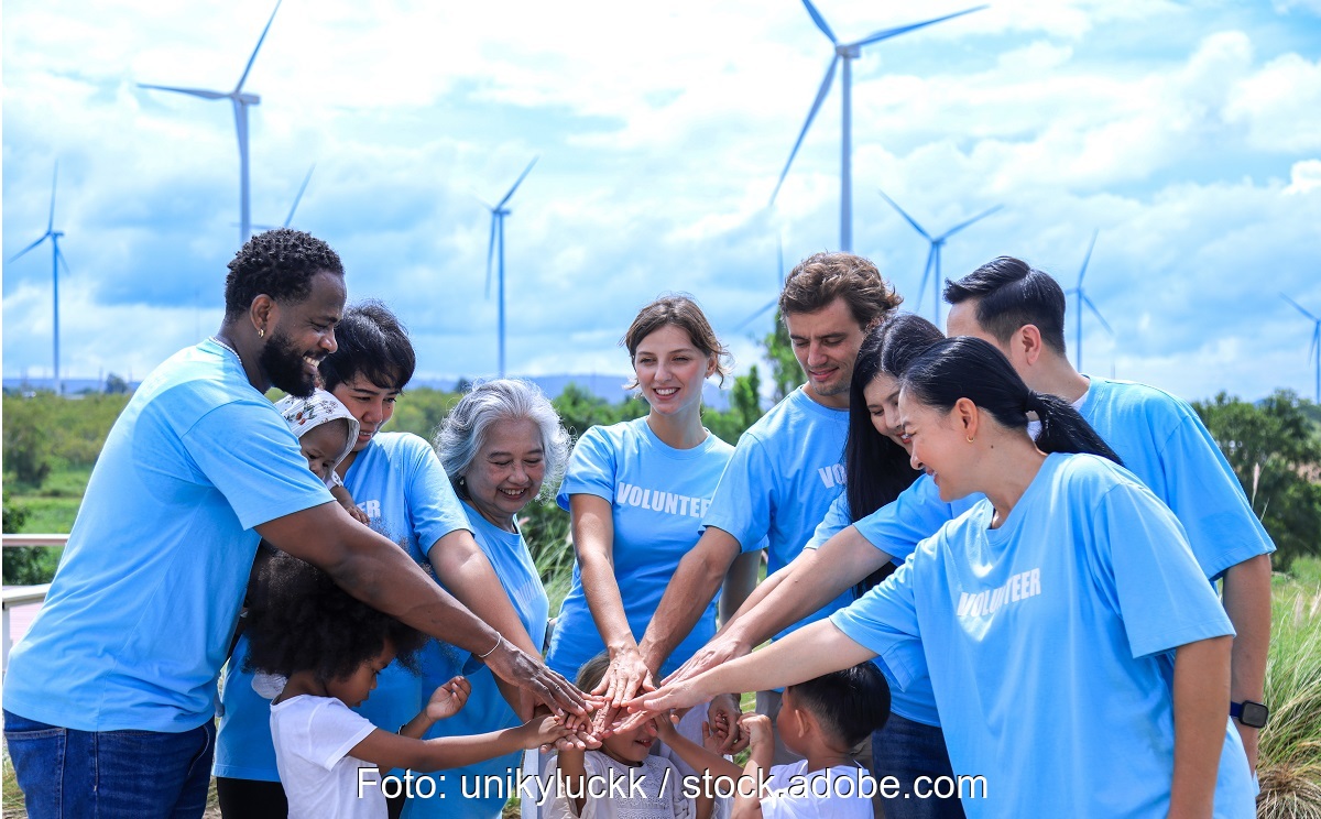 Menschen verbinden die Hände vor Windenergieanlage, Kampagne für Bürgerenergie von BBEn.