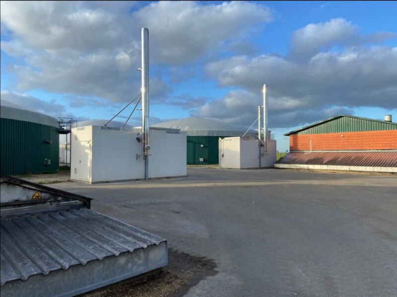 Biogasfermenter und Blockheizkraftwerk auf einem Hof.