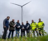 Sieben Männer vor Windenergie-Anlage - Bürgerwind-Projekt Beelen