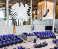 Plenarsaal im Bundestag mit blauen Sitzreihen und Bundesadler - hier soll die "kleine EEG-Novelle" eingebracht werden.