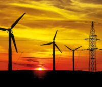 Zu sehen sind Windenergie-Anlagen an Land vor untergehender Sonne. Der Bund will mit dem Wind-an-Land-Gesetz den Windenergieausbau voranbringen.