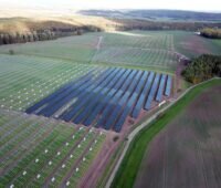 Luftbild eines sehr großen Solarparks auf grüner Fläche im Bau.