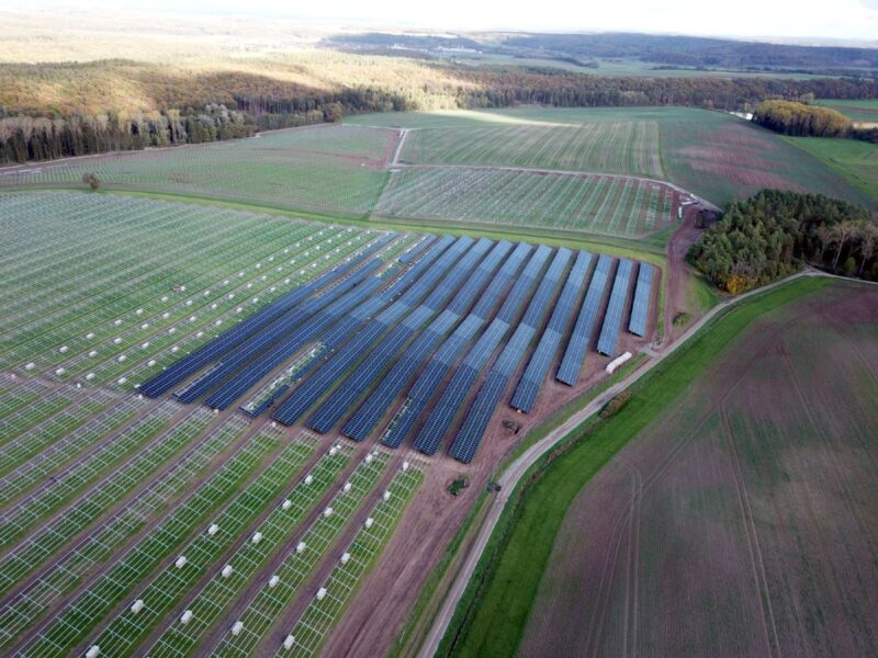 Luftbild eines sehr großen Solarparks auf grüner Fläche im Bau.